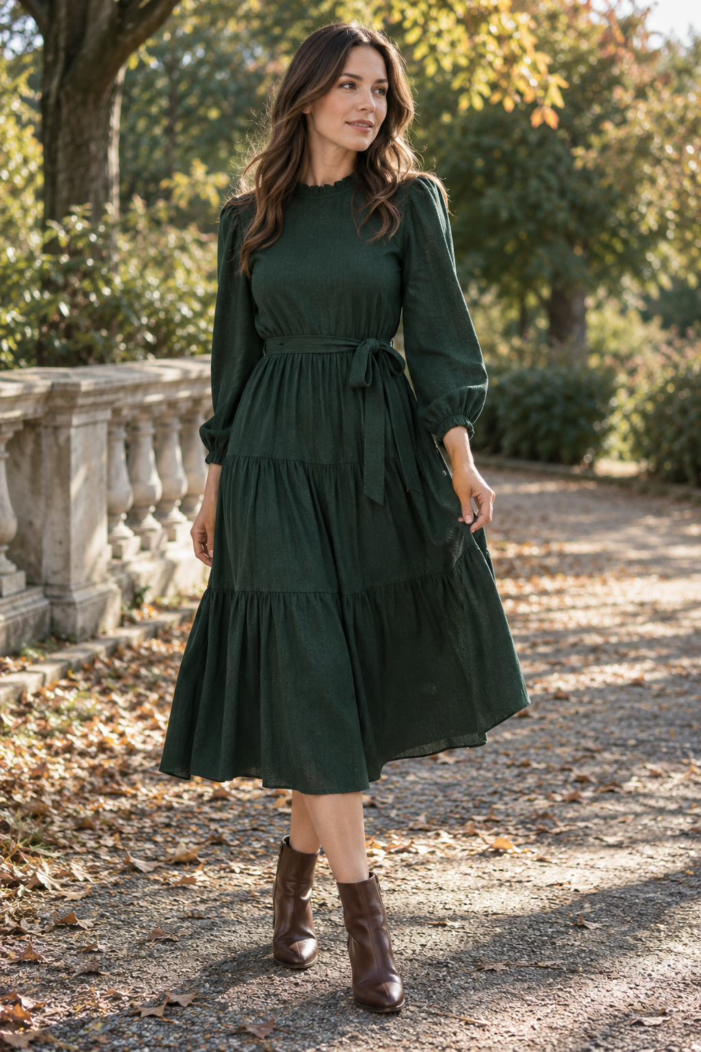 Adult model in a dark green midi dress with ankle boots at a park